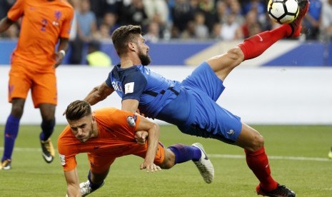 Olivier Giroud (kanan) dari Prancis ketika berduel dengan pemain Belanda Wesley Hoedt (kiri) pada kualifikasi Piala Dunia 2018 Grup A. Prancis mengalahkan Belanda 4-0 pada laga yang dihelat di Stadion Stade de France, Paris.