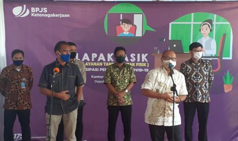 Ombudsman Apresiasi Layanan BP Jamsostek di Masa Pandemi. Foto: Anggota Ombudsman La Ode Isa (berdiri di depan baju ungu) dan Dirut BP Jamsostek Agus Susanto (berdiri di depan baju putih) saat memberikan keterangan pers di Kantor BP Jamsostek cabang Depok, Jawa Barat, Kamis (25/6).