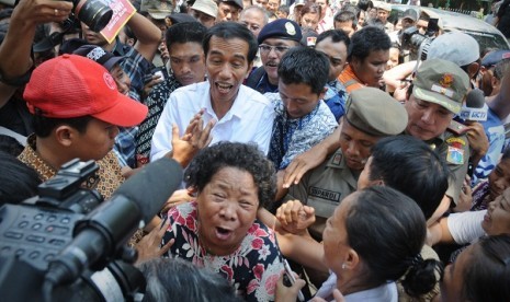 On the first day of his job as governor of Jakarta, Joko Widodo (in white) visits some slum areas in Jakarta, on Tuesday.  