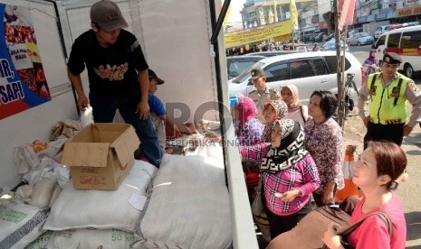  Operasi Pasar Ramadhan 2015: Petugas Bulog melayani pembeli saat menggelar Operasi Pasar Bulog 2015 di kawasan Pasar Benhil, Jakarta, Jumat (26/6).