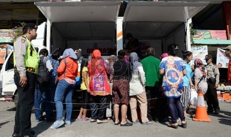 Operasi Pasar Ramadhan 2015: Petugas Bulog melayani pembeli saat menggelar Operasi Pasar Bulog 2015 di kawasan Pasar Benhil, Jakarta, Jumat (26/6).