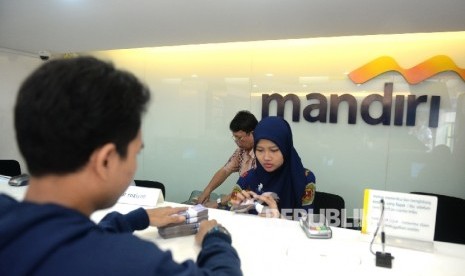 Nasabah menyetorkan uang tunai di salah satu cabang Bank mandiri, Jakarta, Jumat (6/5).  (Republika/Wihdan Hidayat)