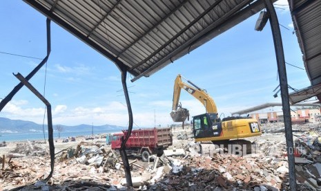 Operator alat berat membersihkan puing bangunan yang rusak pascagempa dan tsunami di Kawasan Pusat Pergudangan di Kelurahan Tondo, Palu, Sulawesi Tengah, Senin (22/10/2018). 