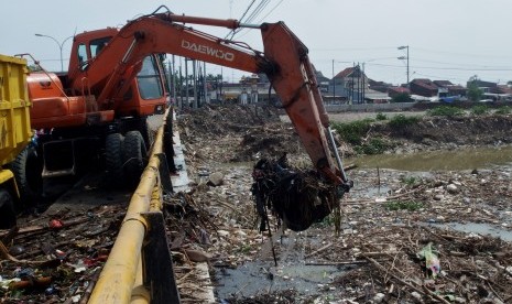 (ILUSTRASI) Alat berat mengeruk sampah di bawah jembatan.