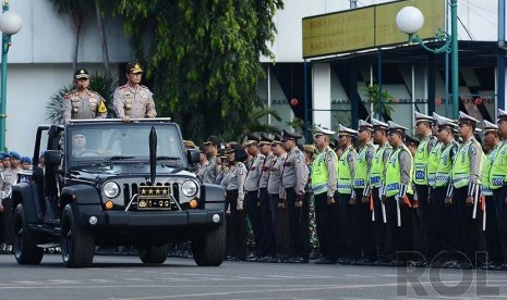 OPS Lilin 2014. Sejumlah anggota kepolisian bersiap untuk mengikuti apel gelar pasukan Operasi Pasukan Terpusat (OPS) Lilin di Lapangan Lalu Lintas, Polda Metro Jaya, Jakarta Selatan, Selasa (23/12).