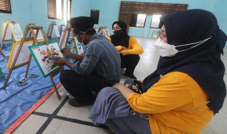 Orang Dengan Gangguan Jiwa (ODGJ) (kiri) ditemani petugas pendamping mewarnai gambar di Posyandu Jiwa di Kelurahan Ngampel, Kota Kediri, Jawa Timur, Kamis (25/8/2022). Pemerintah Kota Kediri gencar menyelenggarakan Posyandu Jiwa guna mempermudah masyarakat untuk mengakses layanan pengobatan dan konsultasi kesehatan jiwa.