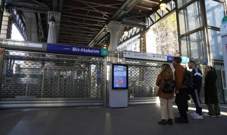 Orang-orang berdiri di depan stasiun kereta bawah tanah yang ditutup Kamis, 10 November 2022 di Paris. Pemogokan pekerja, menuntut upah yang lebih tinggi menutup setengah dari jalur kereta bawah tanah di ibukota Prancis pada hari Kamis, mengganggu kelas dan layanan publik lainnya pada hari pemogokan nasional dan protes oleh pengemudi kereta api dan operator bus, guru dan pekerja sektor publik lainnya.