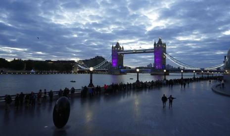 Orang-orang berjalan dalam antrian melewati Tower Bridge untuk memberi penghormatan kepada mendiang Ratu Elizabeth II selama Lying-in State, di Westminster Hall, di London, Inggris, Jumat, 16 September 2022. Lembaga otoritas keuangan Inggris (FCA) mengatakan pada perusahaan asuransi untuk membantu konsumen yang kesulitan dengan biaya hidup.