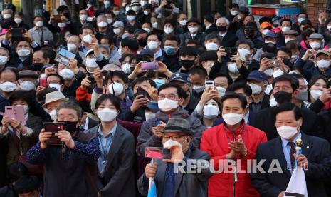 Orang-orang dengan memakai masker wajah mendengarkan pidato kandidat oposisi utama Partai gabungan untuk Masa Depan Hwang Kyo-ahn saat kampanye di Seoul, Korea Selatan, Senin (13/4). Pemilihan akan diadakan pada tanggal 15 April, ada Sekitar 14.300 tempat pemungutan suara di seluruh korea untuk memilih anggota parlemen.