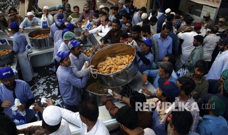 Orang-orang membeli makanan Iftar atau makanan berbuka puasa di sebuah masjid di Karachi Pakistan, Selasa, (7/5/2019). 