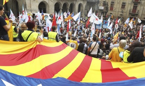 Orang-orang membentangkan bendera pro-kemerdekaan Katalunya dalam sebuah demonstrasi di Santiago de Compostela, Provinsi Galicia, Spanyol, Sabtu (30/9). Katalunya mengadakan referendum kemerdekaan pada Ahad (1/10), meski telah dilarang oleh Mahkamah Konstitusi Spanyol.