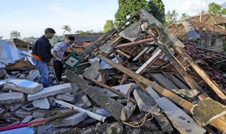 Orang-orang mencari barang-barang yang dapat digunakan dari rumah mereka yang hancur dalam gempa Senin di Cianjur, Jawa Barat, Indonesia, Kamis, 24 November 2022. Gempa berkekuatan 5,6 menyebabkan ratusan orang tewas, terluka dan hilang ketika bangunan runtuh dan warga yang ketakutan berlarian menyelamatkan diri. Pulau Jawa utama Indonesia. 