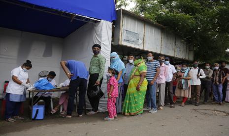 Orang-orang mengantre untuk mendapatkan vaksin COVID-19 selama perjalanan vaksinasi khusus oleh perusahaan kota di halte bus di Ahmedabad, India, Jumat, 17 September 2021. India belum pertimbangkan vaksin booster karena warga terinfeksi Covid secara alami.