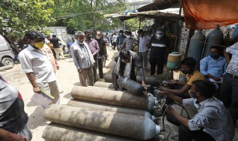 Orang-orang mengantre untuk mengisi ulang oksigen dalam silinder di New Delhi, India, Jumat, 23 April 2021. India menempatkan tanker oksigen di kereta ekspres khusus ketika rumah sakit besar di New Delhi pada hari Jumat meminta lebih banyak persediaan untuk menyelamatkan COVID-19 di media sosial.