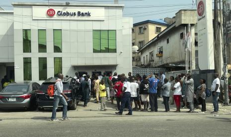 Orang-orang mengantri untuk menarik uang dari mesin ATM di luar bank di Lagos, Nigeria, Selasa, 7 Februari 2023. Bank sentral Nigeria telah memperpanjang batas waktu untuk menukar mata uang lamanya dengan uang kertas yang didesain ulang setelah perubahan tersebut memicu kekurangan uang tunai. Pada hari Selasa, 14 Maret 2023, uang kertas lama dan yang didesain ulang masih belum tersedia untuk ribuan orang yang mengantre di bank di ibu kota Nigeria, Abuja.