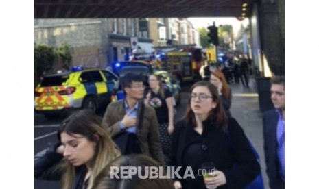 Orang-orang meninggalkan tempat kejadian ledakan di stasiun kereta bawah tanah London barat daya di London pada hari Jumat, (15/9).