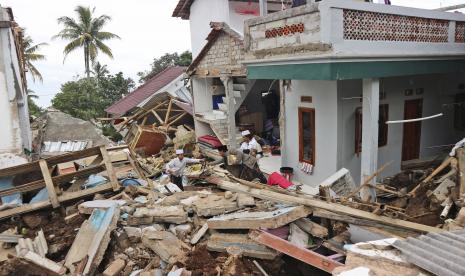 Orang-orang menyelamatkan barang-barang dari puing-puing di reruntuhan Pesantren Al Buroq yang rusak parah saat gempa Senin, di Cianjur, Jawa Barat, Indonesia, Rabu, 23 November 2022. Lebih banyak penyelamat dan relawan dikerahkan Rabu di daerah yang hancur pada Pulau Jawa utama Indonesia untuk mencari korban tewas dan hilang akibat gempa yang menewaskan ratusan orang. 