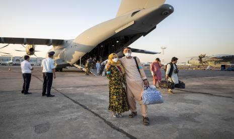 Orang-orang yang dievakuasi dari Afghanistan berpose di depan pesawat Bundeswehr Jerman setelah tiba di bandara di Tashkent, Uzbekistan, Selasa, 17 Agustus 2021. Angkatan bersenjata federal mengevakuasi warga Jerman dan pasukan lokal Afghanistan dari Kabul.