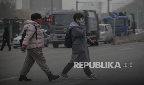  Warga tampak memakai masker berjalan di Beijing, China, 5 November 2021. China menggulirkan strategi nol kasus Covid-19.