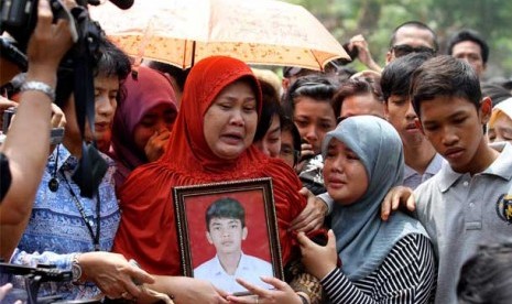  Orang tua almarhum Alawy Yusianto, Ibu Endang Puji (tengah) menyaksikan prosesi pemakaman anaknya Alawy Yusianto di pemakaman Poncol, Pudurenan, Tangerang, Banten, Selasa (25/9). Almarhum siswa SMA 6 Alawy ditusuk dengan celurit ketika terjadi tawuran pel