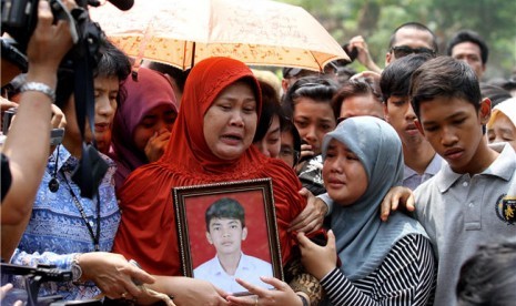 Orang tua almarhum Alawy Yusianto, Ibu Endang Puji (tengah), menyaksikan prosesi pemakaman anaknya di pemakaman Poncol, Pudurenan, Tangerang, Banten, Selasa (25/9). 