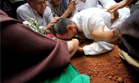  Orang tua almarhum Alawy Yusianto, Tauri Yusianto, memeluk dan menangisi foto anaknya Alawy Yusianto ketika pemakaman almarhum Alawy Yusianto di pemakaman Poncol, Pudurenan, Tangerang, Banten, Selasa (25/9). 