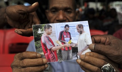 Orang tua korban kecelakaan pesawat Trigana Air PK-YRN Matius menunjukkan foto anaknya Eki Kimki yang menjadi penumpang pesawat naas tersebut di crisis center kompleks Bandara Sentani, Kabupaten Jayapura, Papua, Selasa (18/8).