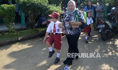 Orang tua mendampingi murid saat hari pertama sekolah di SDN Malaka Sari 04 Pagi, Jakarta Timur, Senin (18/7).Republika/Yasin Habibi