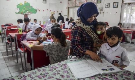 Orang tua murid memberikan penjelasan terkait mata pelajaran kepada siswa di SDN Pondok Cina 1, Kota Depok, Jawa Barat, Selasa (15/11/2022).