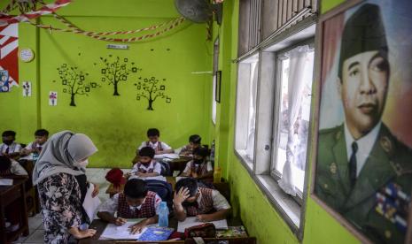 Orang tua murid memberikan penjelasan terkait mata pelajaran kepada siswa di SDN Pondok Cina 1, Kota Depok, Jawa Barat, Selasa (15/11/2022). Siswa SDN Pondok Cina 1 terpaksa harus diajar oleh orang tua murid karena tidak ada guru yang berani mengajar akibat polemik alih fungsi lahan sekolah yang akan dibangunkan masjid agung.