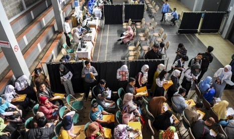 Orangtua dan calon siswa mengantre penyerahan dan pemeriksaan berkas pendaftaran Penerimaan Peserta Didik Baru (PPDB) 2019 tingkat SMA-SMK di SMAN 2 Bandung, Jawa Barat, Senin (17/6/2019).