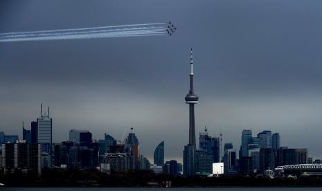 Organisasi nonprofit The Canadian Snowbirds terbang mengelilingi CN Tower di Toronto, Kanada, sebagai penghormatan pada warga Kanada yang terlibat dalam pencegahan penyebaran Covid-19, Ahad (10/5).