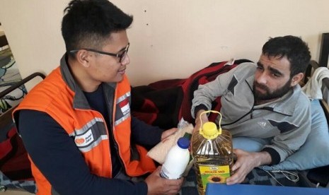 Overseas Department Head Rumah Zakat Joko Pamungkas bercakap-cakap dan memberikan bantuan paket makanan kepada pengungsi Suriah yang terluka akibat perang, Selasa (18/4).