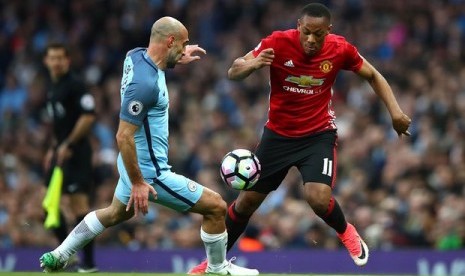 Pablo Zabaleta (kanan) menghadang Anthony Martial dalam Derby Manchester, Jumat (28/4).