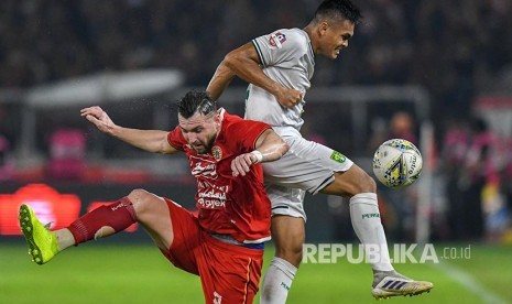 Marko Simic (kiri) berebut bola dengan  Rachmat Irianto pada laga Indonesia di Stadion Utama Gelora Bung Karno (GBK), Jakarta, Selasa (17/12). Rachmat Irianto menjadi kapten Persebaya dalam laga ini.