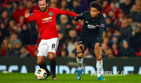 Juan Mata (kanan) menggocek bola pada laga Liga Europa antara Manchester United melawan AZ Alkmaar di Old Trafford, Manchester, Jumat (13/12) dini hari. 