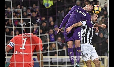 Giovanni Simeone (kiri)  dan bek Juventus Giorgio Chiellini (kanan) berebut bola pada laga Serie A ACF Fiorentina melawan Juventus FC di Stadium Artemio Franchi, Florence Itali, Sabtu (10/2) dini hari.