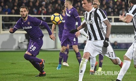 Aksi Mario Mandzukic  (kanan) pada laga Serie A ACF Fiorentina and Juventus FC di Stadium Artemio Franchi, Florence Itali, Sabtu (10/2) dini hari.