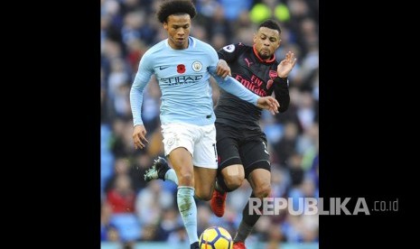 Leroy Sane (kiri) ditempel ketat Francis Coquelin pada pertandingan Liga Primer Inggris di Etihad Stadium, Manchester, Ahad (5/11).