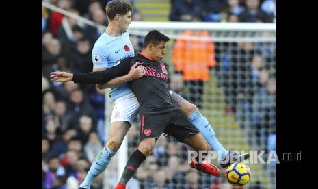  John Stones (kiri) mengganggu Alexis Sanchez pada pertandingan Liga Primer Inggris di Etihad Stadium, Manchester, Ahad (5/11).