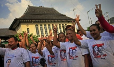 Paguyuban pedagang Pasar Gede mengangkat jari mereka membentuk V (dua) ketika mendengarkan orasi politik di kawasan Pasar Gede, Solo, Jawa Tengah, Ahad (8/6). 