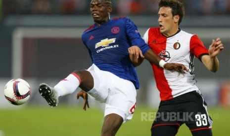 Paul Pogba (kiri) dan Eric Botteghin (kanan) berebut bola pada pertandingan Liga Europa, Jumat (16/9)