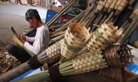 Pak Heri (84) membuat obor sambil menanti pembeli di kawasan Manggarai, Jakarta Selatan, Kamis (26/6). Obor tradisional berbahan dasar bambu tersebut dijual dengan harga Rp 15.000- Rp 25.000. Selain digunakan untuk pawai takbiran obor-obor tersebut juga ba