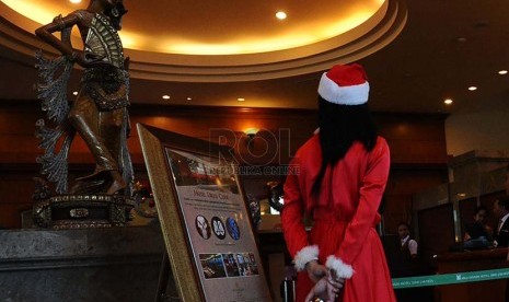 Pekerja mengenakan pakaian atribut natal pada salah satu Hotel di Jakarta, Senin (15/12)