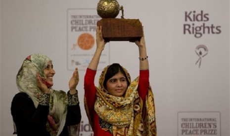 Pakistani teenager Malala Yousafzai, right, who was shot and injured by the Taliban for advocating girls' education, is awarded the International Children's Peace Prize 2013 by 2011 Nobel Peace Prize winner Tawakkol Karman of Yemen, left, during a ceremony