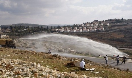 Palestinian and left-wing Israeli demonstrators run away as a foul smelling water cannon is fired by Israeli in the West Bank village of Nabi Saleh, near Ramallah, last year. Conflict of Israel and Palestine become the hottest spot in the world in modern e