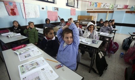 Palestinian first-graders sit with their schoolbooks during class in the West Bank city of Ramallah on Febryary 4. Palestine is under cash crisis and not able to pay the salary of its civil servants as Israel withold tax revenue taken from occupied territo