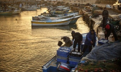 Palestinian fishermen sort boxes containing fish at Gaza Seaport in Gaza City December 13, 2012. Israel completed the main segment of a razor-wire fence along its border with Egypt on Wednesday. The fence stretches from Israel's Red Sea port of Eilat to th