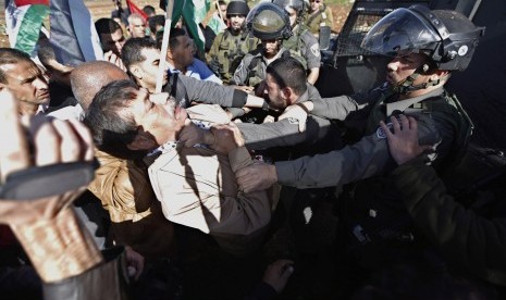 Palestinian minister Ziad Abu Ein (left) scuffles with an Israeli border policeman near the West Bank city of Ramallah December 10, 2014. 