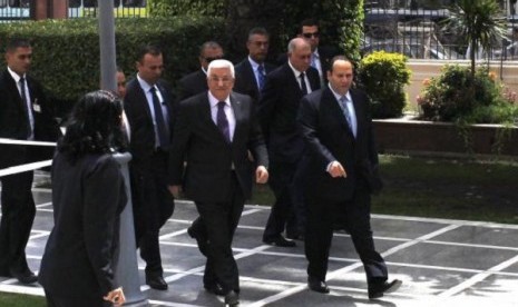 Palestinian President Mahmoud Abbas (center) arrives for an Arab Foreign Ministers' meeting at the Arab League headquarters in Cairo April 9, 2014. 